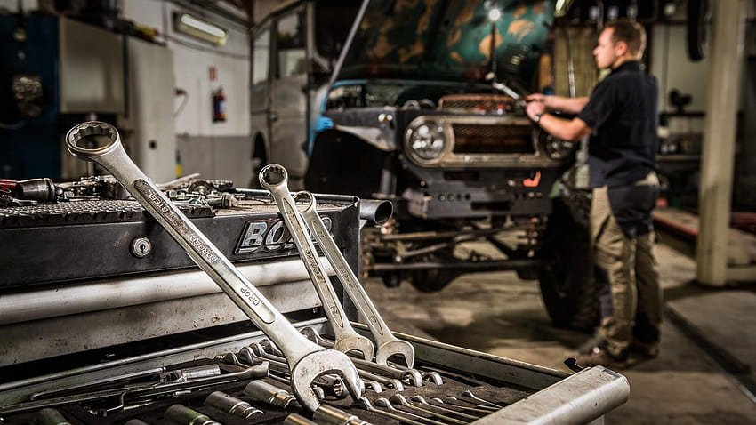 Taller mecánico con herramientas y mecánico trabajando